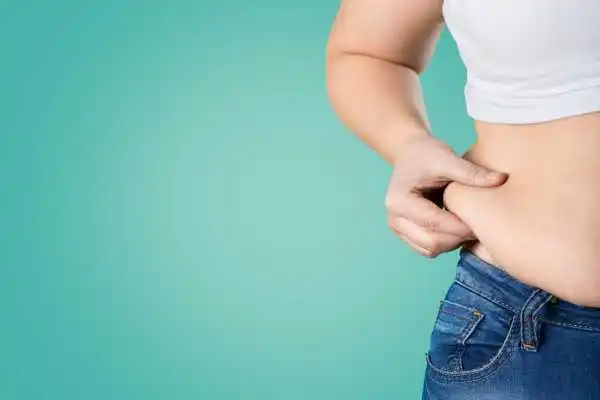 Image of woman pinching her love handles to show weight gain Accrington